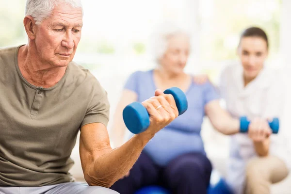 Physiotherapist helping patients with exercises — Stock Photo, Image