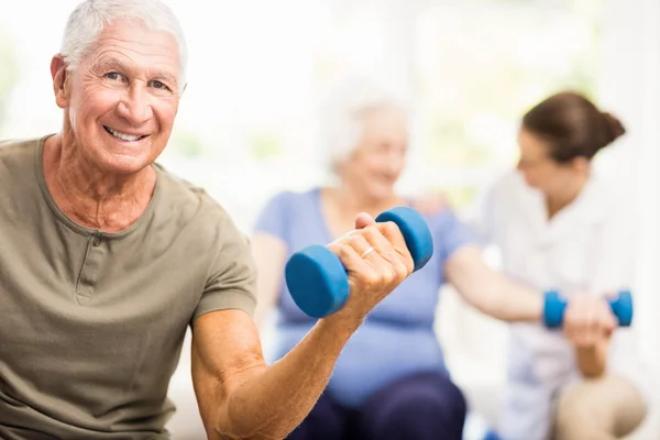 Physiotherapist helping patients with exercises — Stock Photo, Image