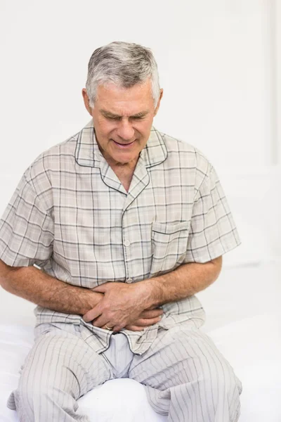 Leidtragender Senior hält sich den Bauch — Stockfoto