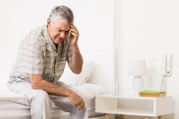 Suffering senior man touching his forehead — Stock Photo, Image