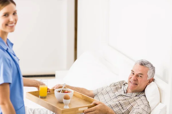 Krankenschwester kümmert sich um leidende Seniorin — Stockfoto