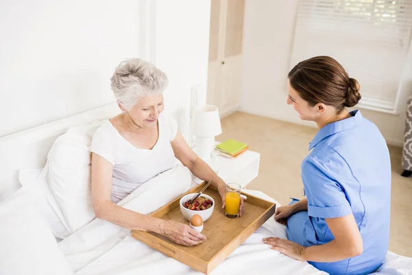 Nurse taking care of suffering senior patient — Stock Photo, Image