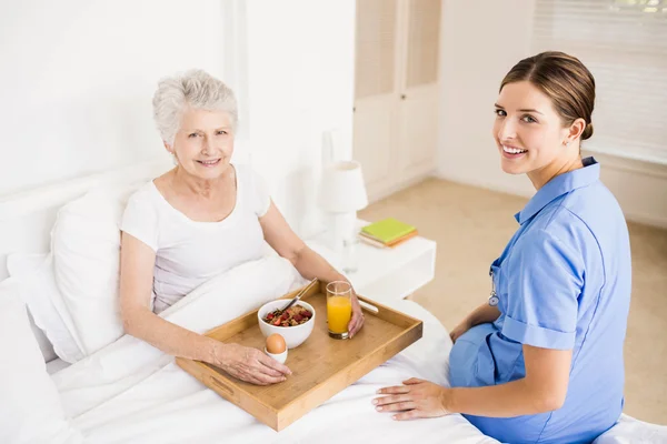 Nurse taking care of suffering senior patient — Stock Photo, Image