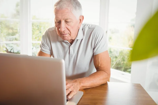 Hombre mayor serio usando su computadora portátil — Foto de Stock