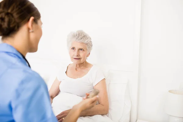 Nurse taking care of suffering senior patient — Stock Photo, Image