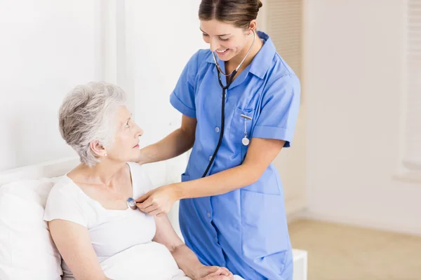 Doctor taking care of suffering senior patient — Stock Photo, Image