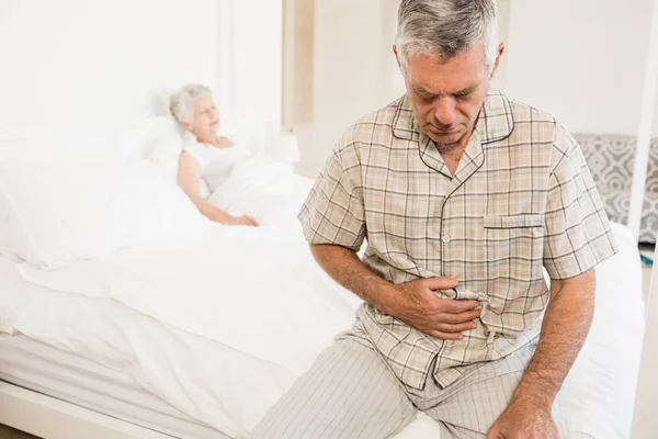 Suffering senior man holding his belly — Stock Photo, Image