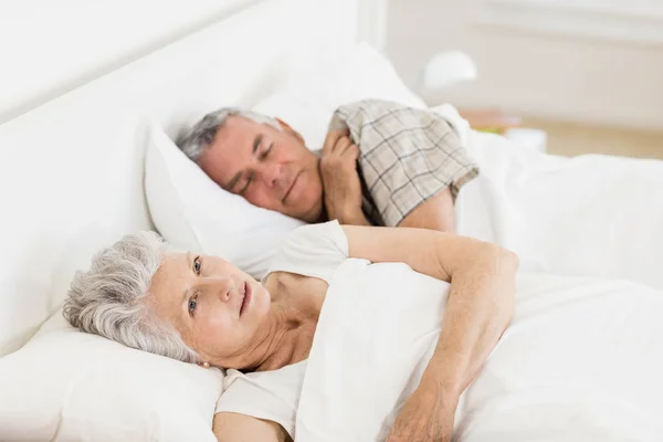 Rijpe vrouw wakker in bed — Stockfoto