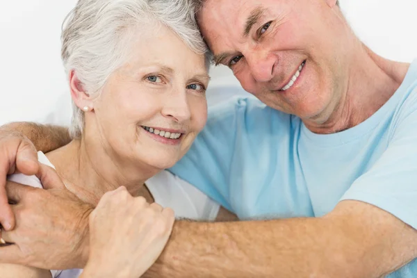 Äldre par ansikte mot ansikte ler mot kameran — Stockfoto