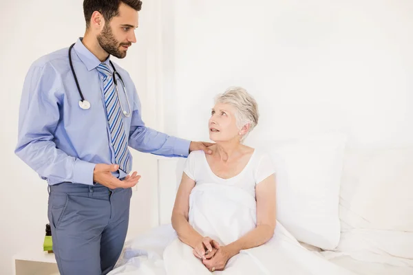 Schöne häusliche Krankenschwester im Gespräch mit älteren Frau — Stockfoto