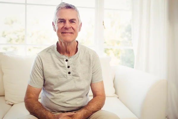 Sorrindo homem sênior sentado no sofá — Fotografia de Stock