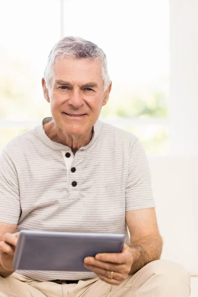 Улыбающийся пожилой человек с помощью планшета — стоковое фото