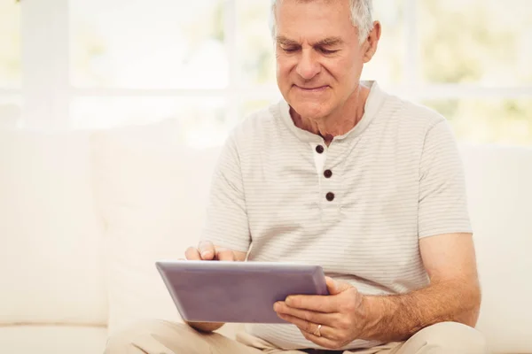 Homem sênior sorrindo usando tablet — Fotografia de Stock