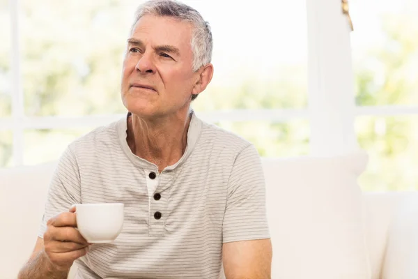 Homme âgé réfléchi tenant tasse — Photo