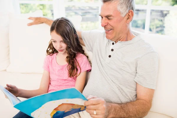 Grandfather and granddaughter reading book — Stock Photo, Image