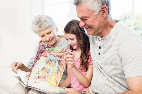 Mor-och farföräldrar med barnbarn läser en bok — Stockfoto