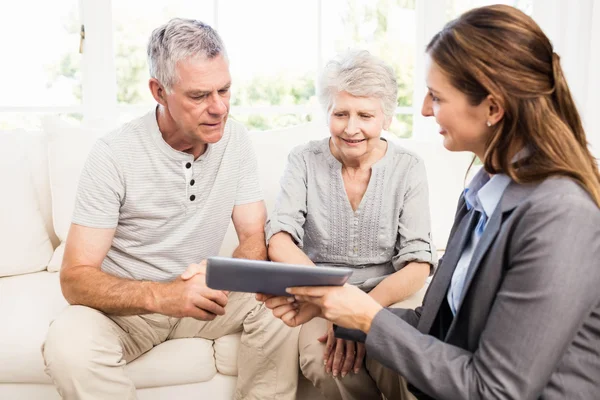 Businesswoman showing tablet to senior couple — Stock Photo, Image