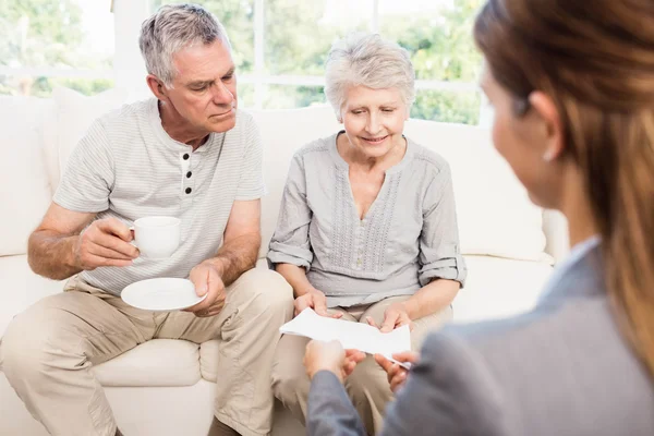 Affärskvinna visar dokument till äldre par — Stockfoto