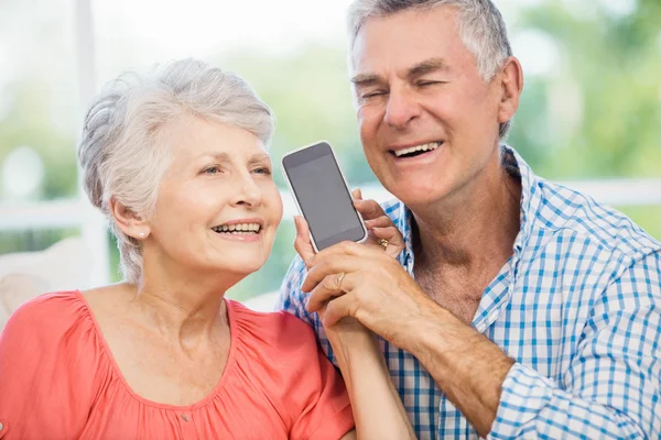 Feliz casal sênior ouvindo smartphone — Fotografia de Stock