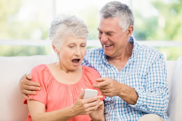 Lachende senior paar met smartphone — Stockfoto