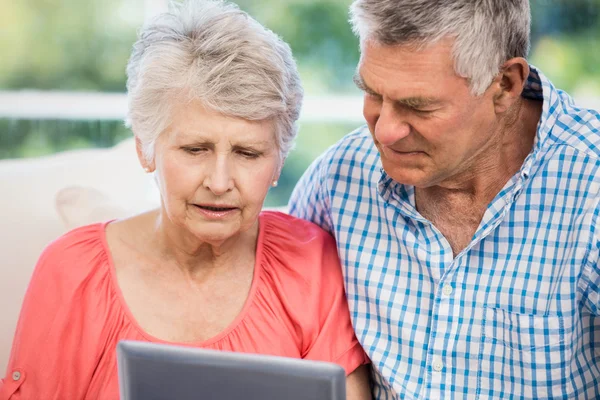 Dudosa pareja de personas mayores utilizando tableta —  Fotos de Stock