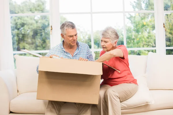 Senior couple opening big box — Stock Photo, Image