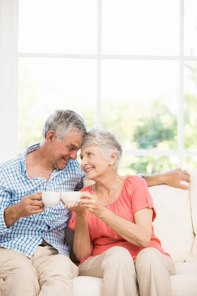 Sorrindo casal sênior brindar com canecas — Fotografia de Stock