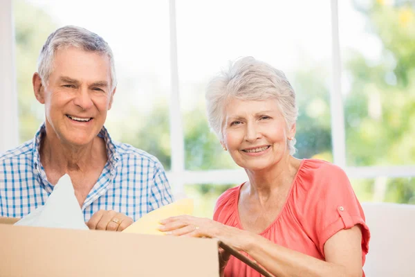 Senior couple opening big box — Stock Photo, Image