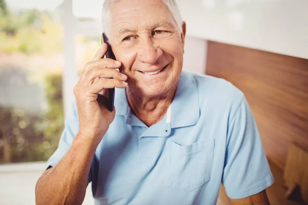 Bir telefon üzerinde gülümseyen kıdemli adam — Stok fotoğraf