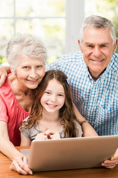 Grandparents and granddaughter using laptop — Stock Photo, Image