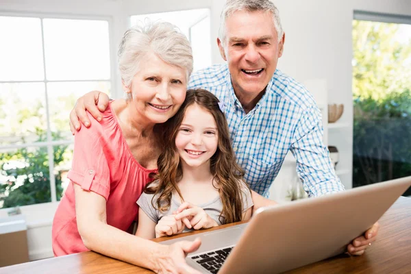 Far-och morföräldrar och barnbarn med laptop — Stockfoto