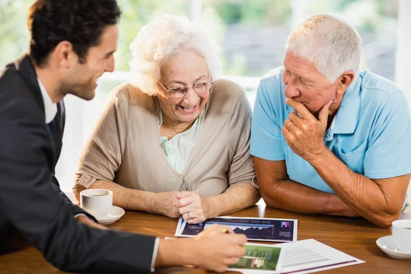 Zakenman bladen tot senior paar tonen — Stockfoto