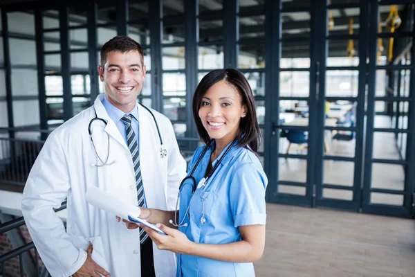 Nurse and doctor smiling at camera — Stock Photo, Image