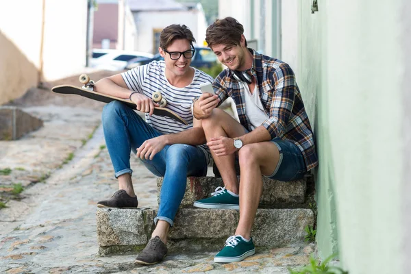 Hip uomini seduti su gradini e guardando smartphone — Foto Stock
