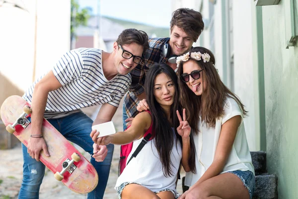 Anca amici prendendo selfie seduto su gradini — Foto Stock