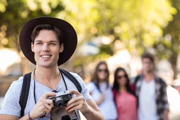 Hip man avec appareil photo numérique souriant — Photo