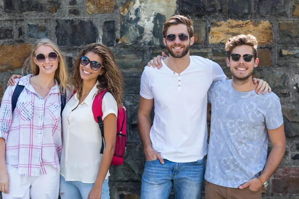 Amigos de la cadera sonriendo a la cámara y apoyados contra la pared —  Fotos de Stock