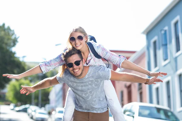 Hip man geven piggy terug naar zijn vriendin — Stockfoto