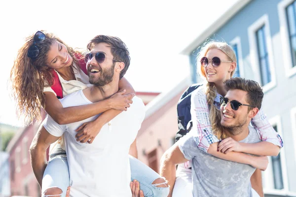 Hippe Männer geben ihren Freundinnen Huckepack zurück — Stockfoto