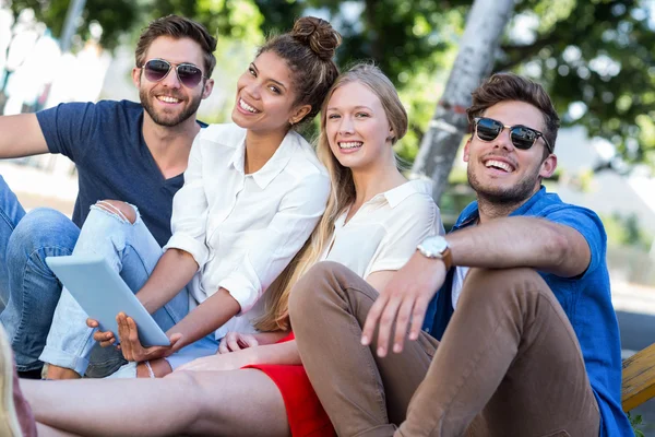 Hüfte Freunde halten Tablet und sitzen auf Gehweg — Stockfoto