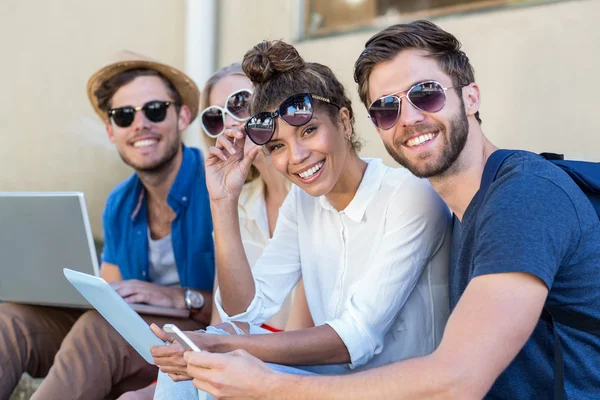 Hüfte Freunde sitzen auf Gehweg — Stockfoto