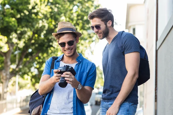 Hip friends looking at digital camera — Stock Photo, Image