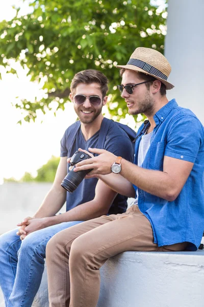 Hip friends looking at digital camera — Stock Photo, Image