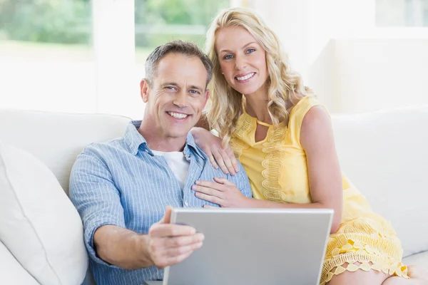 Lyckliga par med laptop i soffan — Stockfoto
