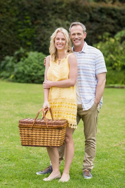 Happy couple holding picnic basket — Stock Photo, Image