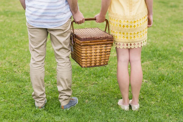 Lykkelig par som holder piknik kurv – stockfoto