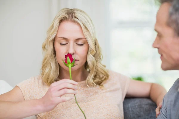 Mooie vrouw ruiken een roos aangeboden door man — Stockfoto