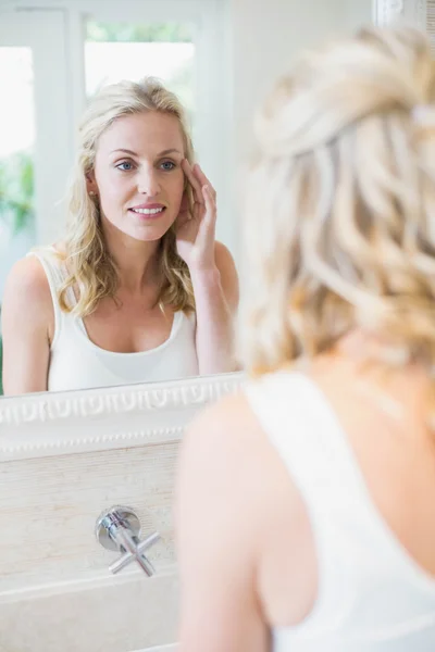 Schöne Frau, die sich selbst im Spiegel betrachtet — Stockfoto