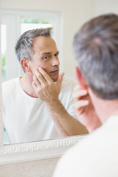 Handsome man looking at himself in the mirror — Stock Photo, Image