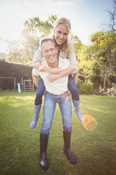 Husband giving piggy back to wife — Stock Photo, Image